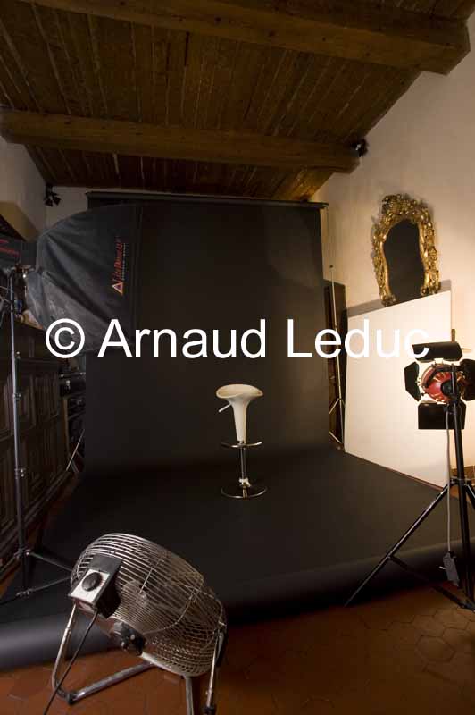 studio photo modulable avec rouleau papierfond photo noir, flash boite à lumière, projecteur mandarine réflecteur et gros ventilateur
